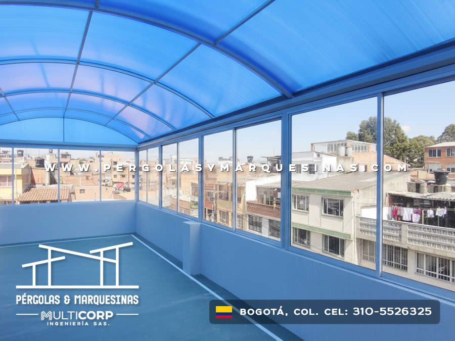 Cubierta curva azul transparente con ventanales y vista urbana en terraza de Bogotá, Colombia. Multicorp Ingeniería SAS. Cubierta curva azul transparente con ventanales y vista urbana en terraza de Bogotá, Colombia. Multicorp Ingeniería SAS.