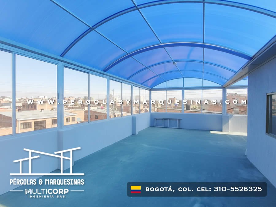 Cerramiento en policarbonato curvo azul con estructura metálica y ventanas en terraza de Bogotá, Colombia. Multicorp Ingeniería SAS. Cerramiento en policarbonato curvo azul con estructura metálica y ventanas en terraza de Bogotá, Colombia. Multicorp Ingeniería SAS.