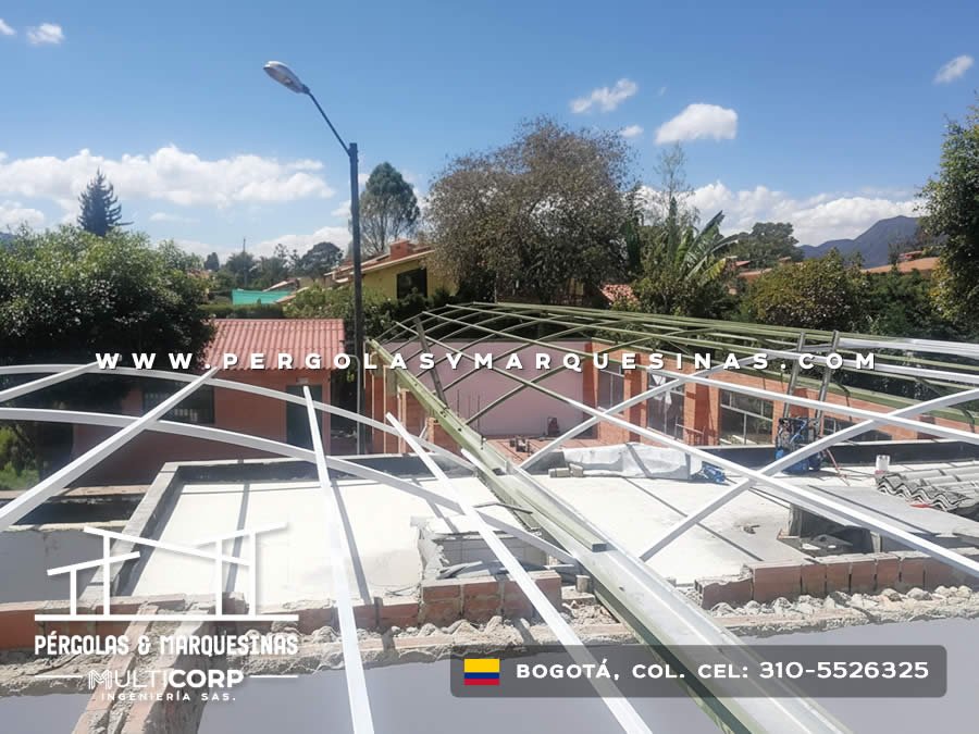 Armazón de acero blanco en montaje sobre azotea con vista residencial y montañas de Bogotá, Colombia. Multicorp Ingeniería SAS. Armazón de acero blanco en montaje sobre azotea con vista residencial y montañas de Bogotá, Colombia. Multicorp Ingeniería SAS.