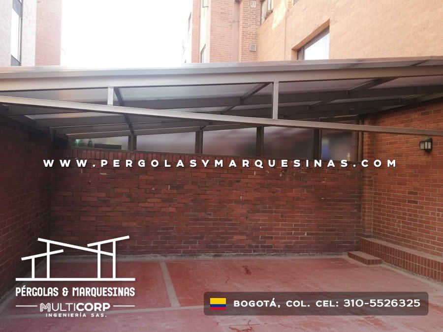 Estructura metálica gris con techo de láminas sobre terraza de edificio con paredes de ladrillo en Bogotá, Colombia. Multicorp Ingeniería SAS. Estructura metálica gris con techo de láminas sobre terraza de edificio con paredes de ladrillo en Bogotá, Colombia. Multicorp Ingeniería SAS.