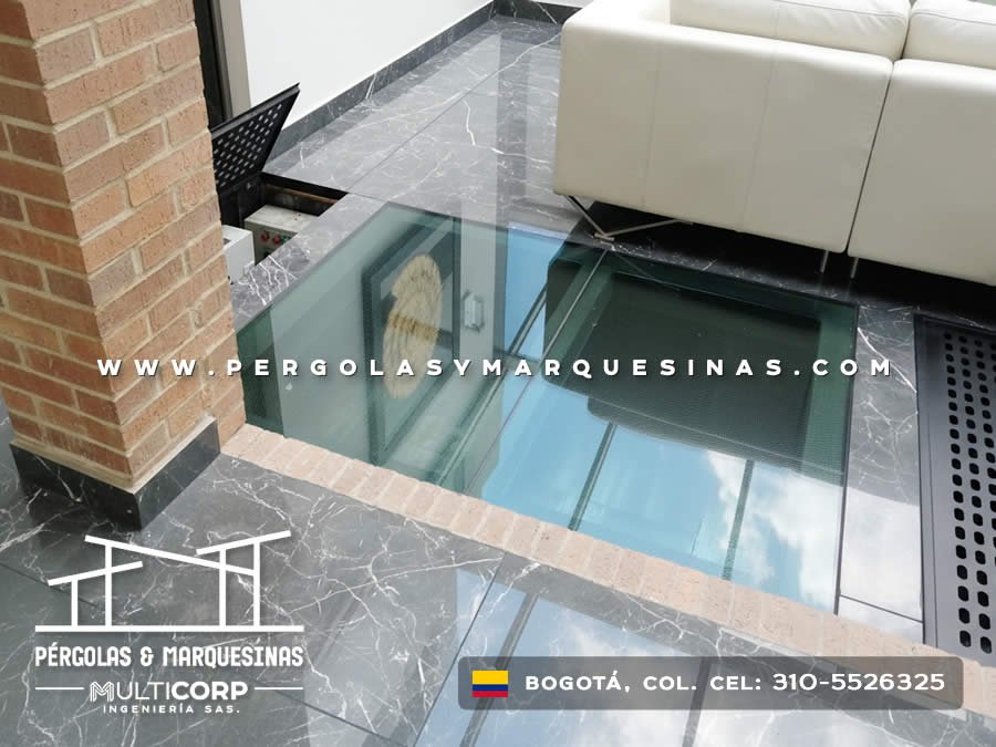 Piso de vidrio templado sobre sótano con iluminación natural en sala moderna de Bogotá, Colombia. Multicorp Ingeniería SAS. Piso de vidrio templado sobre sótano con iluminación natural en sala moderna de Bogotá, Colombia. Multicorp Ingeniería SAS.