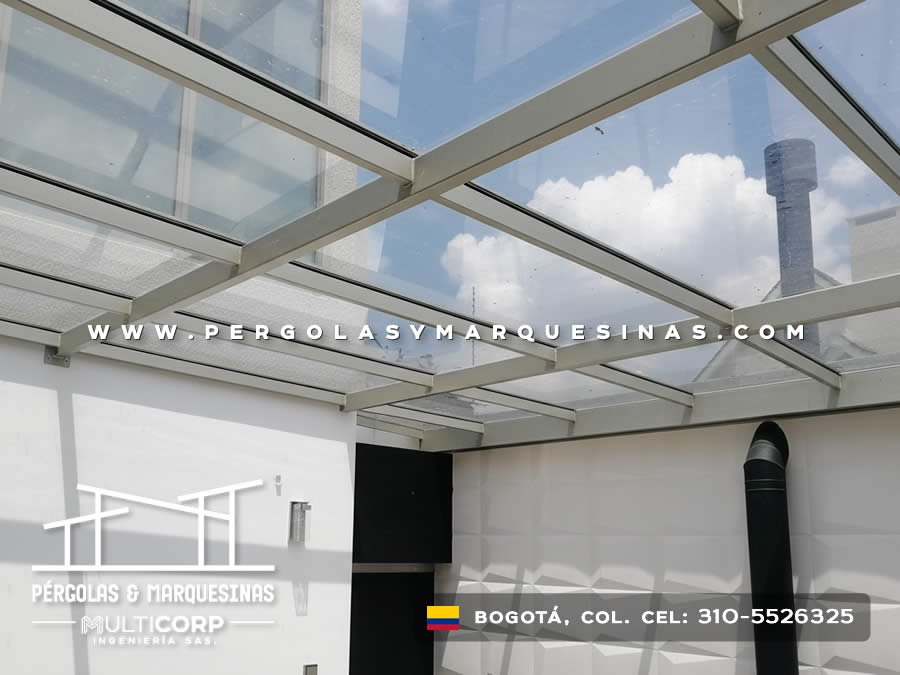 Techo de vidrio con vigas blancas sobre terraza con chimenea en residencia moderna de Bogotá, Colombia. Multicorp Ingeniería SAS. Techo de vidrio con vigas blancas sobre terraza con chimenea en residencia moderna de Bogotá, Colombia. Multicorp Ingeniería SAS.
