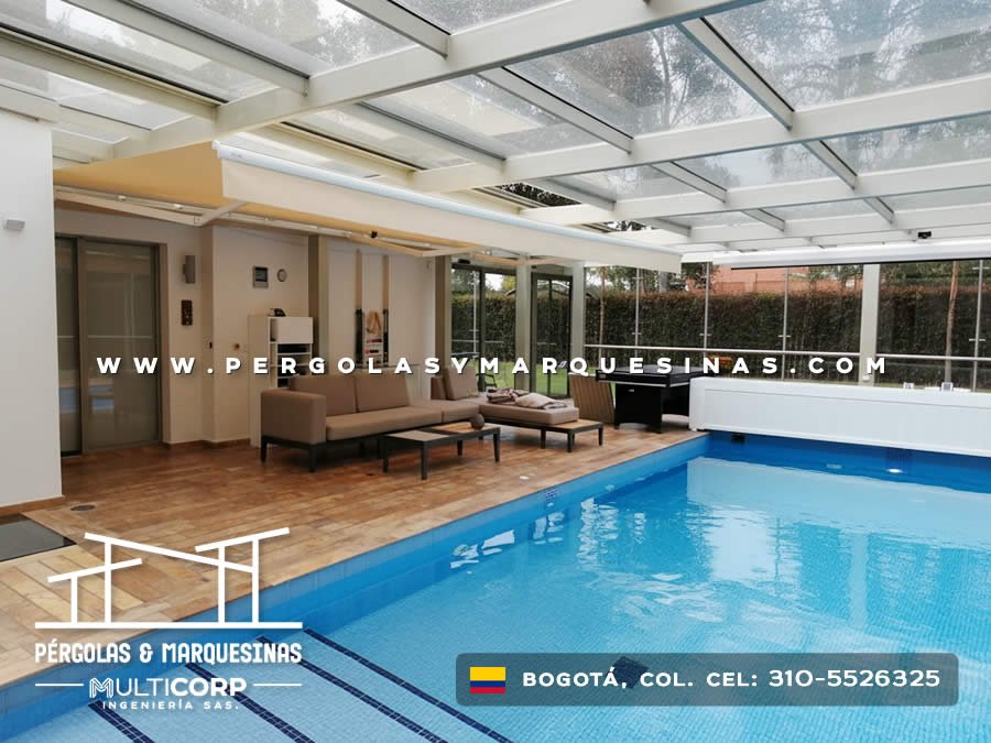 Cubierta de cristal con perfiles metálicos sobre piscina con área lounge en jardín de Bogotá, Colombia. Multicorp Ingeniería SAS. Cubierta de cristal con perfiles metálicos sobre piscina con área lounge en jardín de Bogotá, Colombia. Multicorp Ingeniería SAS.