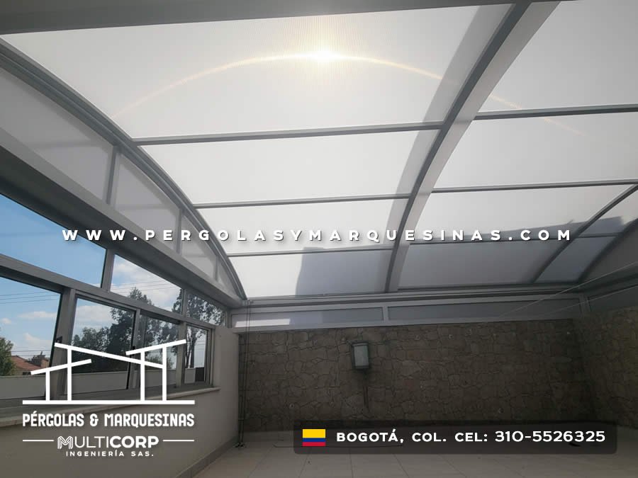 Estructura de policarbonato con vigas grises sobre terraza con ventanas de aluminio en casa de Bogotá, Colombia. Multicorp Ingeniería SAS. Estructura de policarbonato con vigas grises sobre terraza con ventanas de aluminio en casa de Bogotá, Colombia. Multicorp Ingeniería SAS.