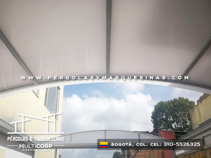 Estructura curva translúcida con perfiles metálicos sobre terraza con vista al cielo en Bogotá, Colombia. Multicorp Ingeniería SAS. Estructura curva translúcida con perfiles metálicos sobre terraza con vista al cielo en Bogotá, Colombia. Multicorp Ingeniería SAS.