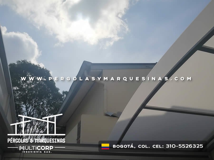 Techo de policarbonato con vigas metálicas grises sobre terraza moderna con vista al cielo en Bogotá, Colombia. Multicorp Ingeniería SAS. Techo de policarbonato con vigas metálicas grises sobre terraza moderna con vista al cielo en Bogotá, Colombia. Multicorp Ingeniería SAS.