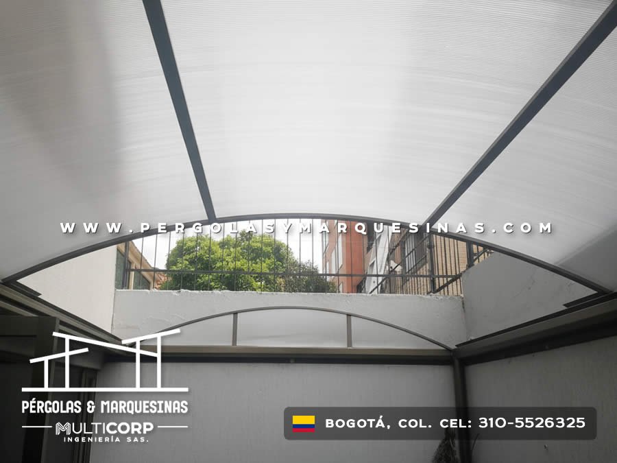 Domo curvo de policarbonato translúcido con estructura metálica negra sobre patio interior en Bogotá, Colombia. Multicorp Ingeniería SAS. Domo curvo de policarbonato translúcido con estructura metálica negra sobre patio interior en Bogotá, Colombia. Multicorp Ingeniería SAS.