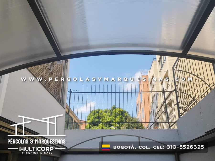Techo curvo de policarbonato translúcido con vigas metálicas sobre patio rodeado de barandas en Bogotá, Colombia. Multicorp Ingeniería SAS. Techo curvo de policarbonato translúcido con vigas metálicas sobre patio rodeado de barandas en Bogotá, Colombia. Multicorp Ingeniería SAS.
