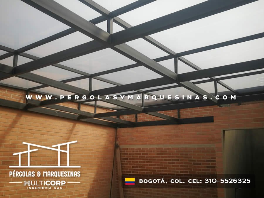 Estructura metálica negra con paneles translúcidos sobre terraza con muro de ladrillo en Bogotá, Colombia. Multicorp Ingeniería SAS. Estructura metálica negra con paneles translúcidos sobre terraza con muro de ladrillo en Bogotá, Colombia. Multicorp Ingeniería SAS.