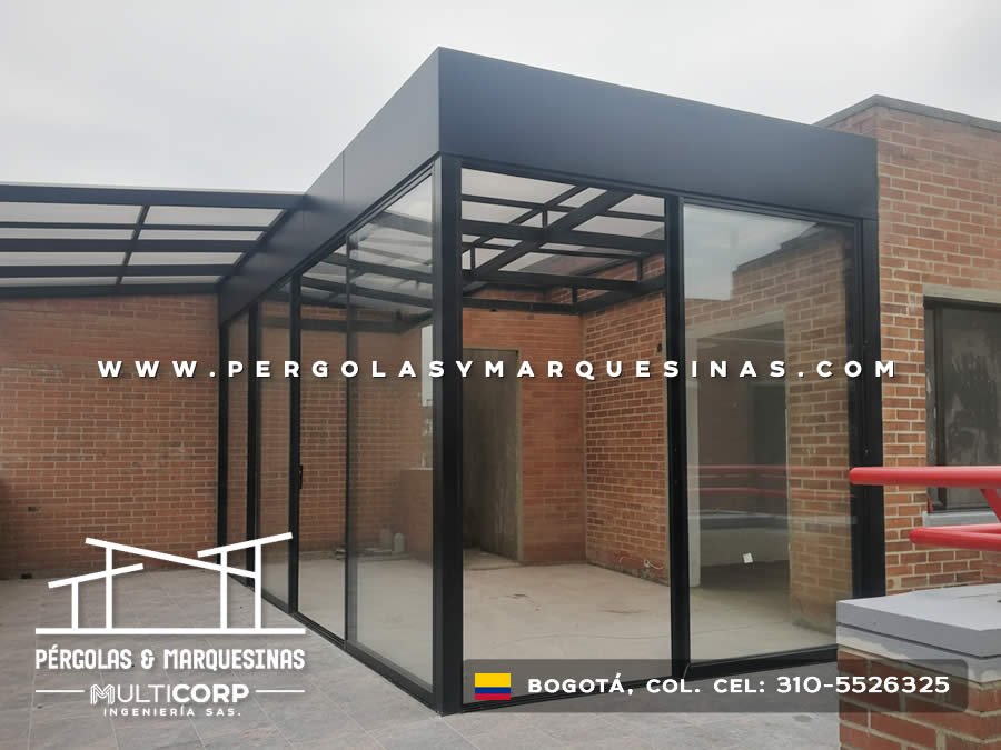 Cerramiento modular con estructura metálica negra y vidrio sobre terraza de edificio residencial en Bogotá, Colombia. Multicorp Ingeniería SAS. Cerramiento modular con estructura metálica negra y vidrio sobre terraza de edificio residencial en Bogotá, Colombia. Multicorp Ingeniería SAS.
