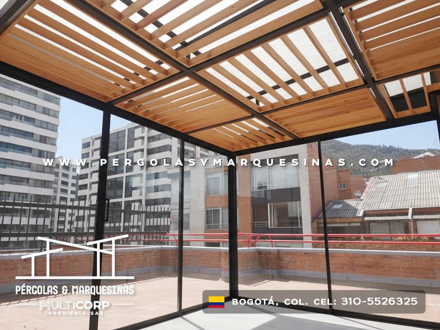 Techo de celosia de madera con vigas metalicas negras sobre terraza acristalada con vista a edificios en Bogotá, Colombia. Multicorp Ingeniería SAS. Techo de celosia de madera con vigas metalicas negras sobre terraza acristalada con vista a edificios en Bogotá, Colombia. Multicorp Ingeniería SAS.