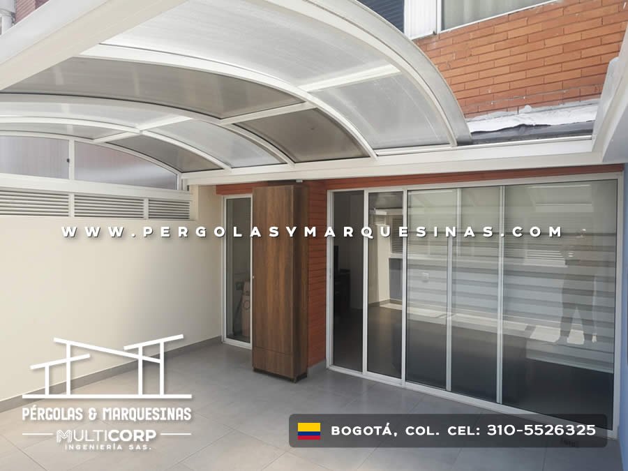 Cubierta curva de policarbonato con estructura blanca sobre terraza moderna con puertas corredizas en Bogotá, Colombia. Multicorp Ingeniería SAS. Cubierta curva de policarbonato con estructura blanca sobre terraza moderna con puertas corredizas en Bogotá, Colombia. Multicorp Ingeniería SAS.