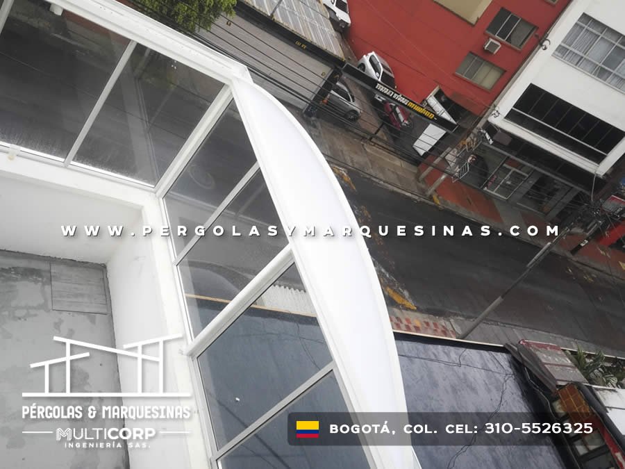 Estructura de vidrio templado triangular con marco blanco sobre balcon de edificio comercial en Bogotá, Colombia. Multicorp Ingeniería SAS. Estructura de vidrio templado triangular con marco blanco sobre balcon de edificio comercial en Bogotá, Colombia. Multicorp Ingeniería SAS.