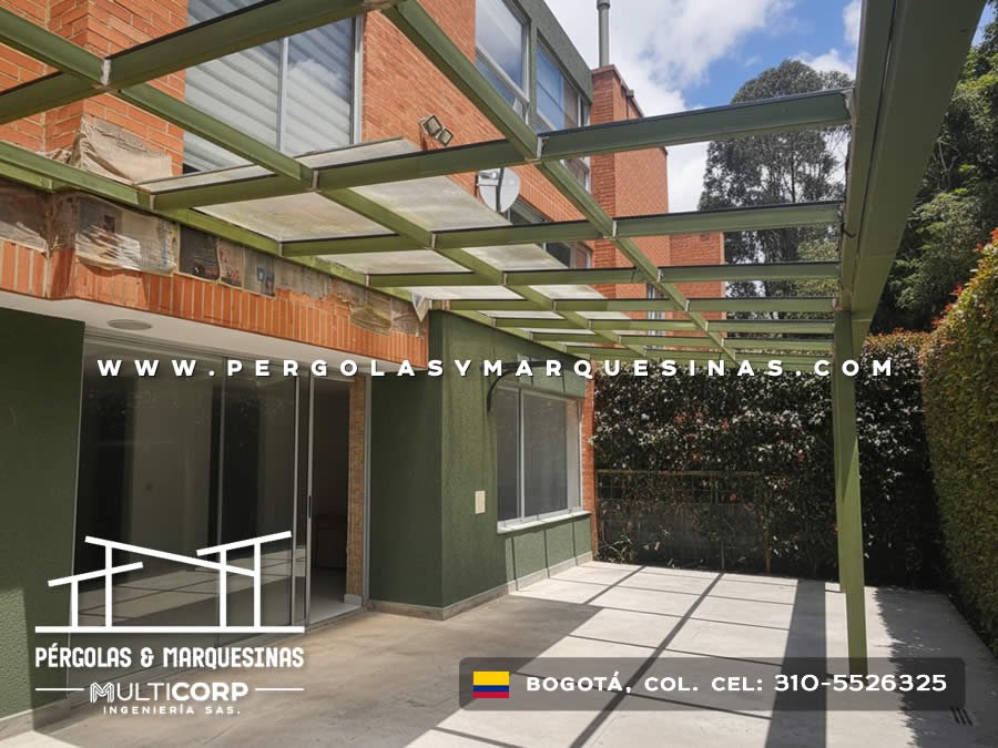 Pergola metalica verde con vigas paralelas sobre terraza de casa con muro de ladrillo y jardin en Bogotá, Colombia. Multicorp Ingeniería SAS. Pergola metalica verde con vigas paralelas sobre terraza de casa con muro de ladrillo y jardin en Bogotá, Colombia. Multicorp Ingeniería SAS.