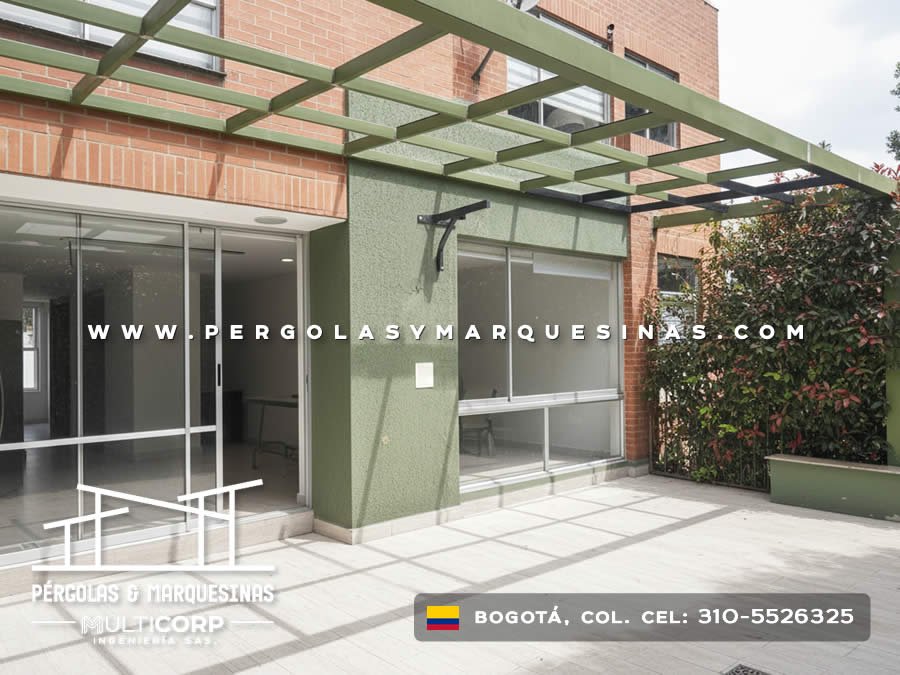 Pergola metalica verde con estructura abierta sobre terraza con puertas vidrio y muro texturizado en Bogotá, Colombia. Multicorp Ingeniería SAS. Pergola metalica verde con estructura abierta sobre terraza con puertas vidrio y muro texturizado en Bogotá, Colombia. Multicorp Ingeniería SAS.