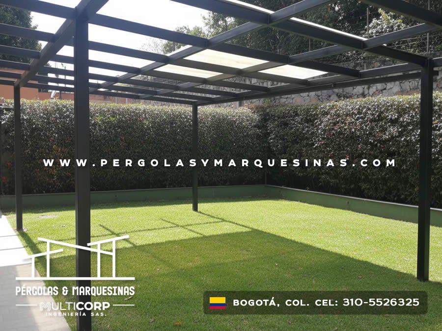 Pergola metalica negra con techo policarbonato translucido sobre jardin cesped artificial con muro piedra en Bogotá, Colombia. Multicorp Ingeniería SAS. Pergola metalica negra con techo policarbonato translucido sobre jardin cesped artificial con muro piedra en Bogotá, Colombia. Multicorp Ingeniería SAS.