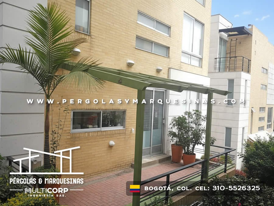 Pergola metalica verde estructura abierta entrada edificio residencial con planta palmera terraza en Bogotá, Colombia. Multicorp Ingeniería SAS. Pergola metalica verde estructura abierta entrada edificio residencial con planta palmera terraza en Bogotá, Colombia. Multicorp Ingeniería SAS.