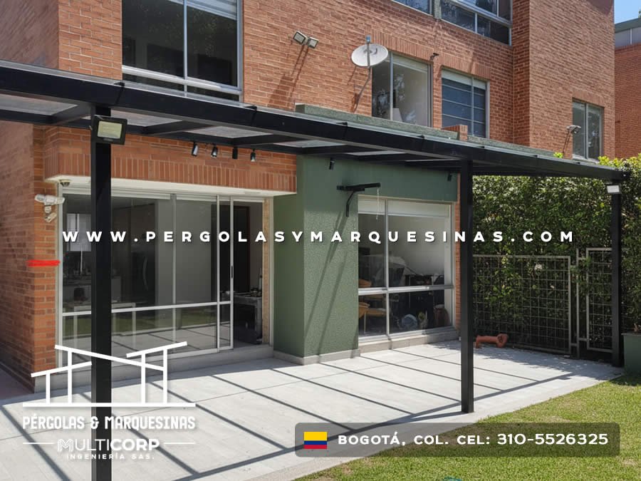 Pergola metalica negra techo policarbonato sobre terraza piso losas edificio ladrillo rojo con pared verde y focos en Bogotá, Colombia. Multicorp Ingeniería SAS. Pergola metalica negra techo policarbonato sobre terraza piso losas edificio ladrillo rojo con pared verde y focos en Bogotá, Colombia. Multicorp Ingeniería SAS.