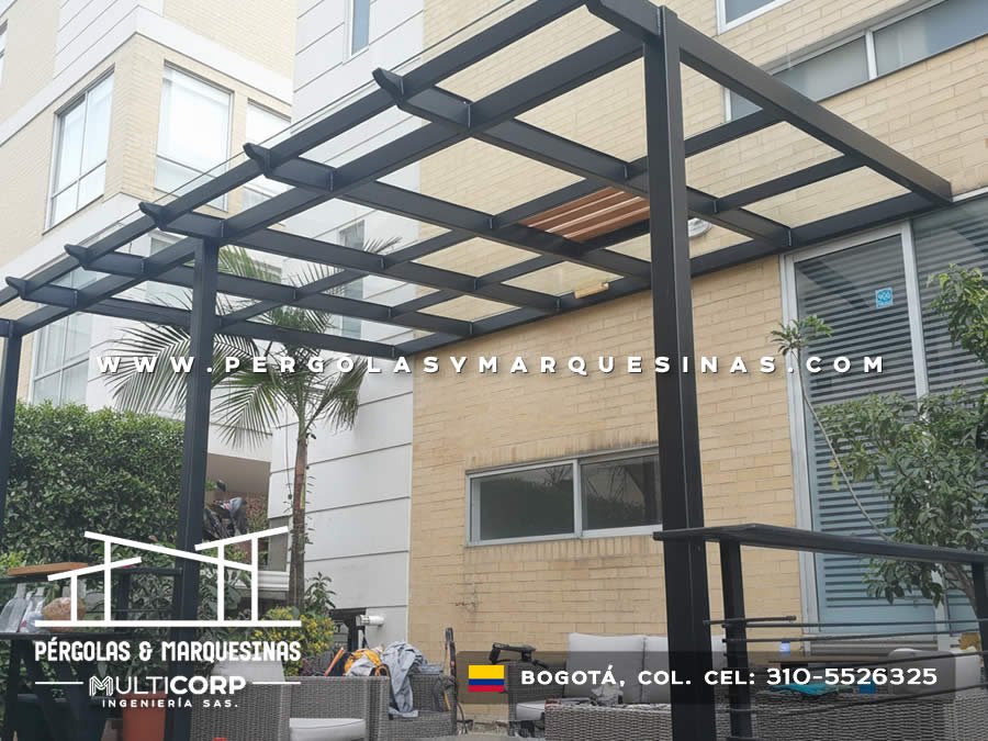 Pergola metalica negra estructura abierta con lamas madera sobre terraza edificio ladrillo amarillo con muebles exterior en Bogotá, Colombia. Multicorp Ingeniería SAS. Pergola metalica negra estructura abierta con lamas madera sobre terraza edificio ladrillo amarillo con muebles exterior en Bogotá, Colombia. Multicorp Ingeniería SAS.