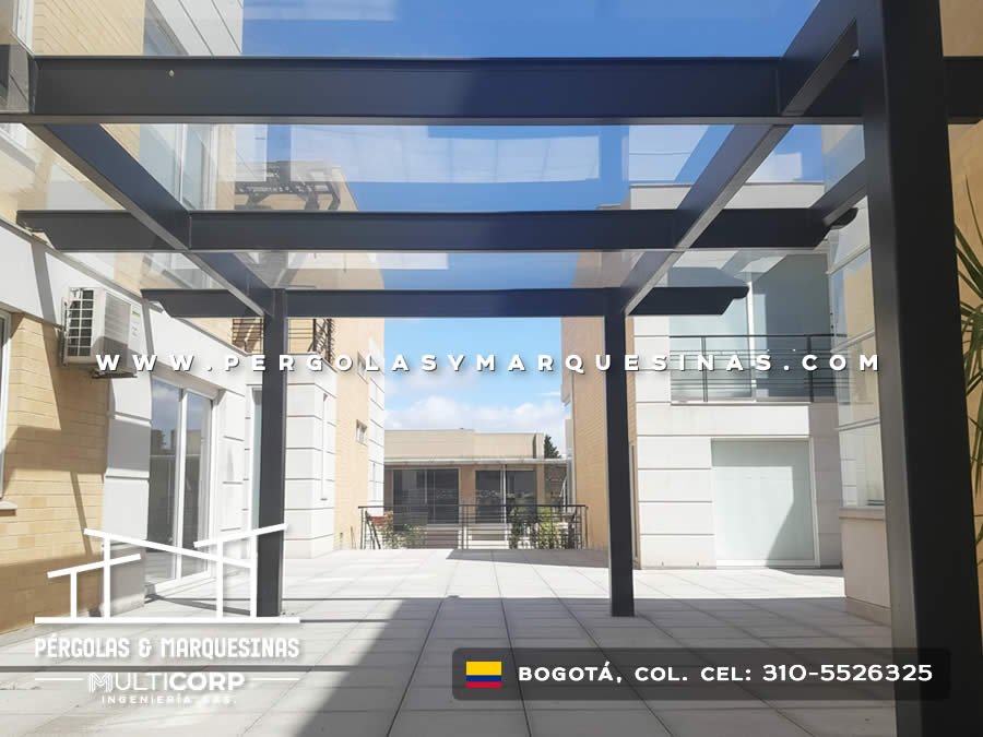 Pergola acristalada metalica negra techo vidrio transparente sobre terraza piso losas edificios urbanos en Bogotá, Colombia. Multicorp Ingeniería SAS. Pergola acristalada metalica negra techo vidrio transparente sobre terraza piso losas edificios urbanos en Bogotá, Colombia. Multicorp Ingeniería SAS.