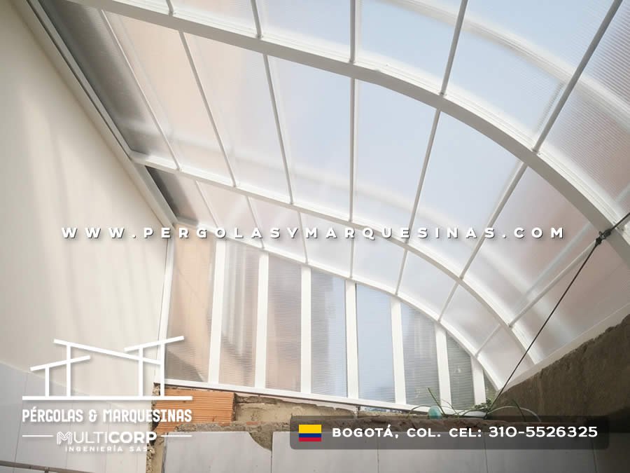 Domo policarbonato curvo blanco con estructura blanca sobre patio interior con muro piedra en Bogotá, Colombia. Multicorp Ingeniería SAS. Domo policarbonato curvo blanco con estructura blanca sobre patio interior con muro piedra en Bogotá, Colombia. Multicorp Ingeniería SAS.