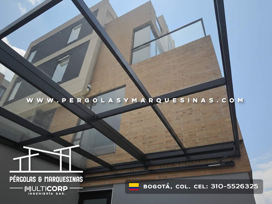 Marquesina acristalada metalica negra techo vidrio sobre entrada edificio ladrillo amarillo con pared gris en Bogotá, Colombia. Multicorp Ingeniería SAS. Marquesina acristalada metalica negra techo vidrio sobre entrada edificio ladrillo amarillo con pared gris en Bogotá, Colombia. Multicorp Ingeniería SAS.