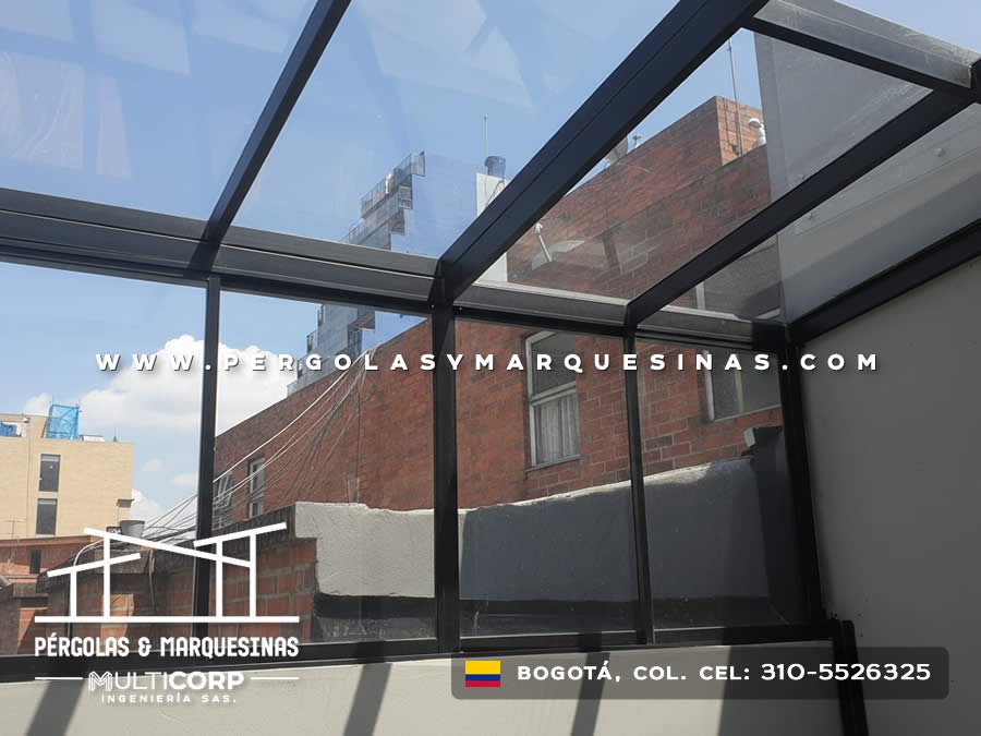 Pergola acristalada metalica negra techo vidrio sobre terraza edificio ladrillo rojo con azoteas urbanas en Bogotá, Colombia. Multicorp Ingeniería SAS. Pergola acristalada metalica negra techo vidrio sobre terraza edificio ladrillo rojo con azoteas urbanas en Bogotá, Colombia. Multicorp Ingeniería SAS.