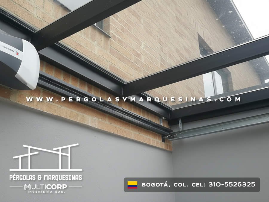 Pergola acristalada metalica negra con techo vidrio deslizante motor sobre espacio edificio ladrillo amarillo en Bogotá, Colombia. Multicorp Ingeniería SAS. Pergola acristalada metalica negra con techo vidrio deslizante motor sobre espacio edificio ladrillo amarillo en Bogotá, Colombia. Multicorp Ingeniería SAS.