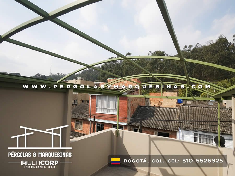 Estructura curva metalica verde sobre terraza edificio con muro divisoria y barrio urbano con arboles en Bogotá, Colombia. Multicorp Ingeniería SAS. Estructura curva metalica verde sobre terraza edificio con muro divisoria y barrio urbano con arboles en Bogotá, Colombia. Multicorp Ingeniería SAS.
