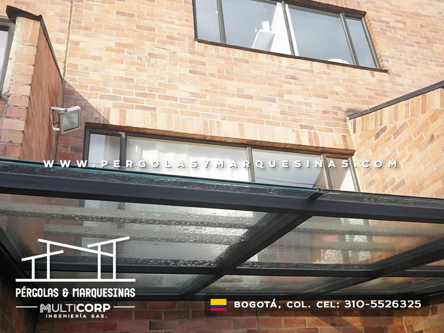 Pergola metalica vidrio templado perspectiva inferior perfiles negros fachada ladrillo ventanas marcos negros en Bogotá, Colombia. Multicorp Ingeniería SAS. Pergola metalica vidrio templado perspectiva inferior perfiles negros fachada ladrillo ventanas marcos negros en Bogotá, Colombia. Multicorp Ingeniería SAS.