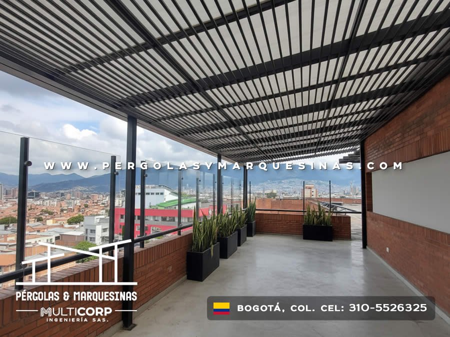 Pergola metalica con laminas negras paralelas sobre terraza residencial con jardineras y vista urbana en Bogotá, Colombia. Multicorp Ingeniería SAS.