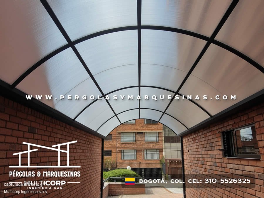 Domo curvo de policarbonato translúcido con estructura metalica arqueada sobre pasillo residencial en Bogotá, Colombia. Multicorp Ingeniería SAS.