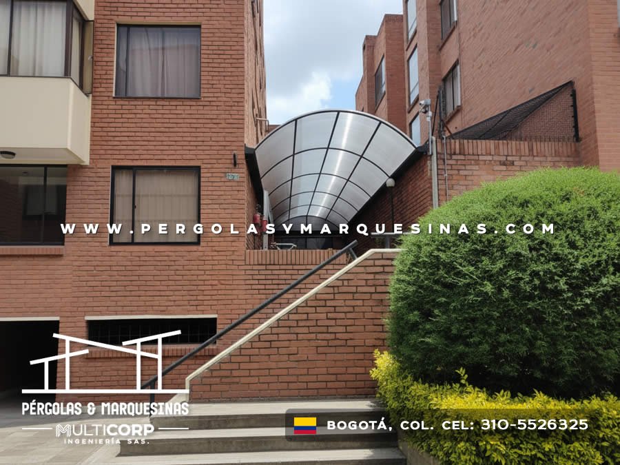 Marquesina curva de policarbonato translúcido con estructura metalica radial en fachada de edificio residencial en Bogotá, Colombia. Multicorp Ingeniería SAS.