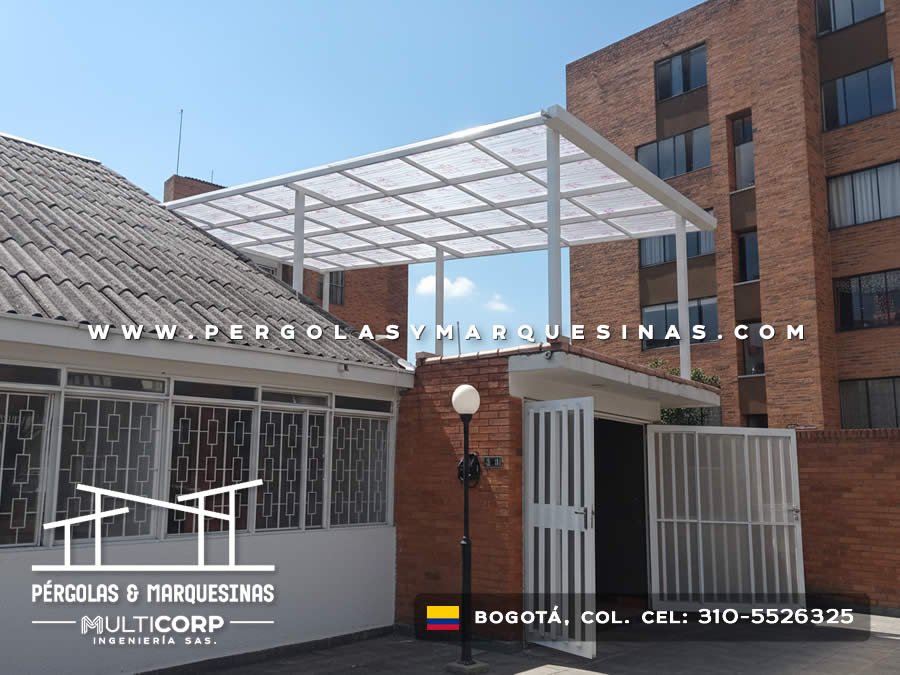 Cubierta metalica blanca con paneles de policarbonato sobre entrada principal de conjunto residencial en Bogotá, Colombia. Multicorp Ingeniería SAS.