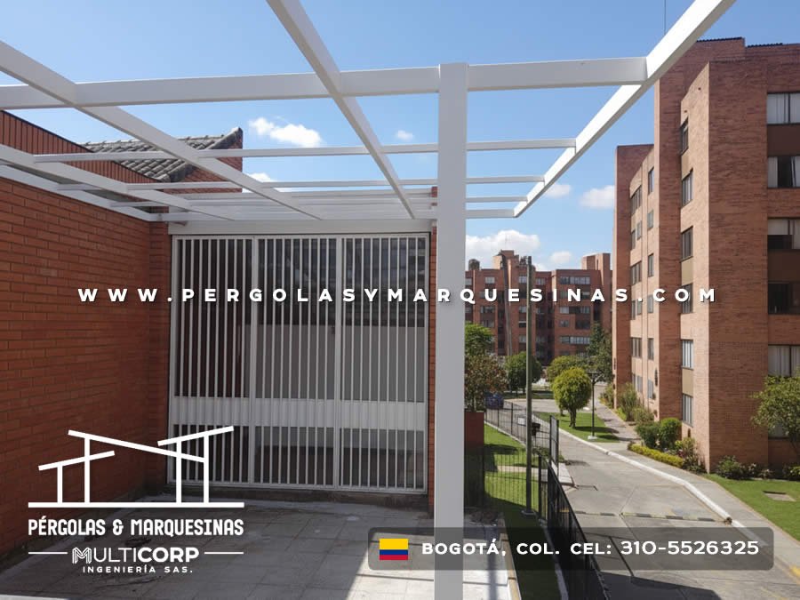Estructura metalica blanca abierta sobre balcon residencial con baranda vertical y vista urbana en Bogotá, Colombia. Multicorp Ingeniería SAS.