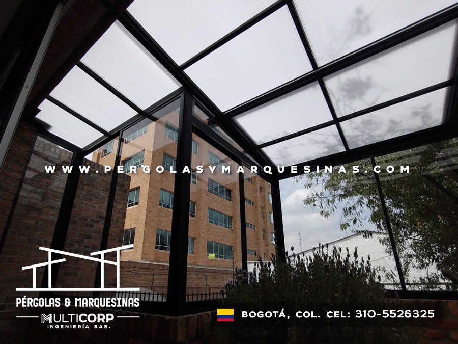 Cubierta metalica negra con paneles de policarbonato translucido sobre terraza residencial con vista urbana en Bogotá, Colombia. Multicorp Ingeniería SAS.
