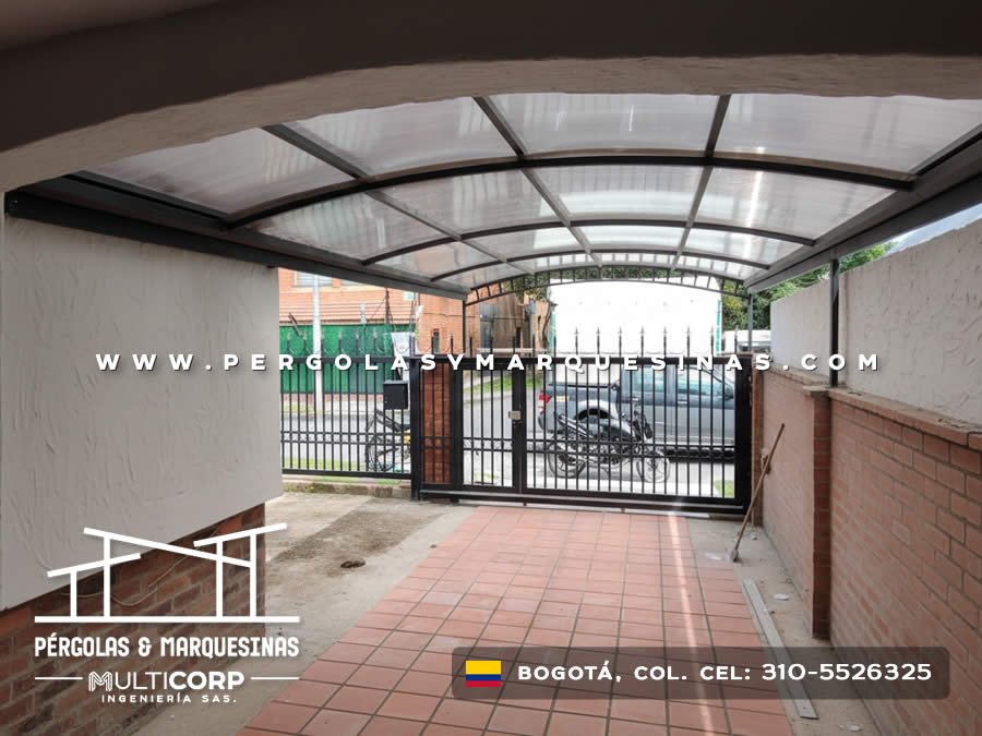 Marquesina curva de policarbonato translucido con estructura metalica negra sobre garaje residencial con puerta en Bogotá, Colombia. Multicorp Ingeniería SAS.