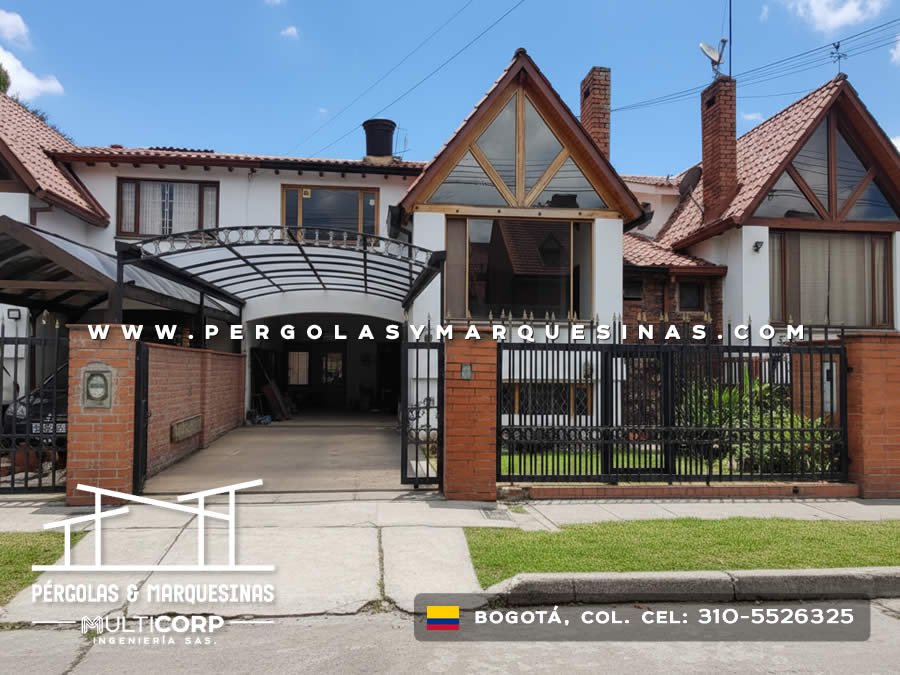 Cubierta arqueada de policarbonato con estructura negra sobre entrada vehicular de casa con reja metalica en Bogotá, Colombia. Multicorp Ingeniería SAS.