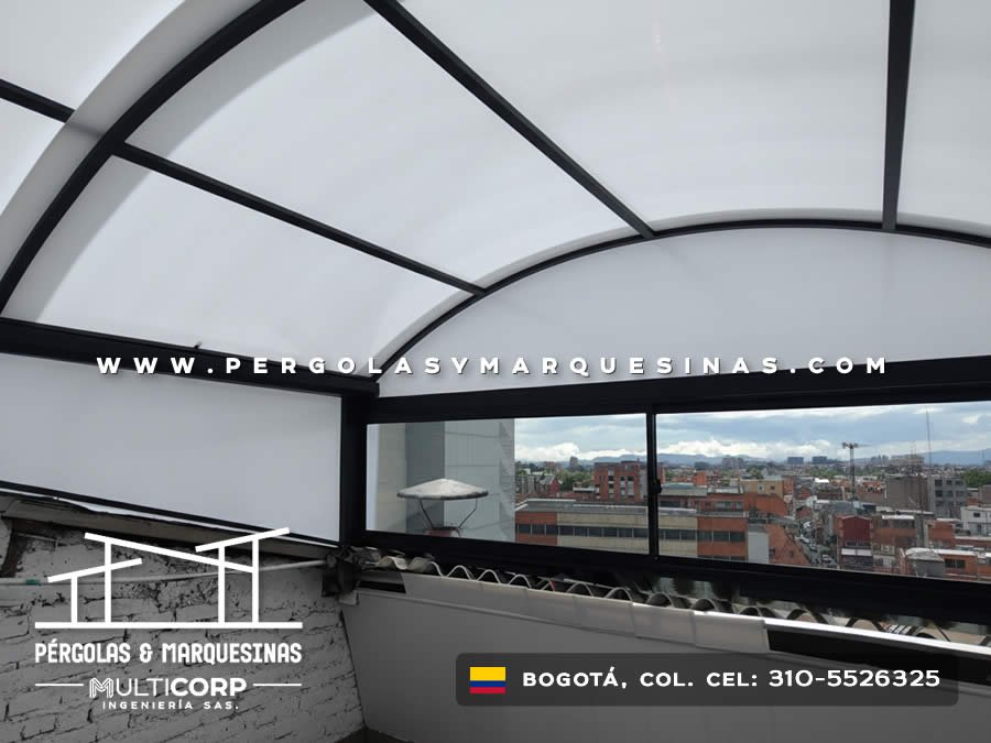 Domo curvo de policarbonato con estructura negra y ventana de vidrio sobre terraza con vista panoramica urbana en Bogotá, Colombia. Multicorp Ingeniería SAS.