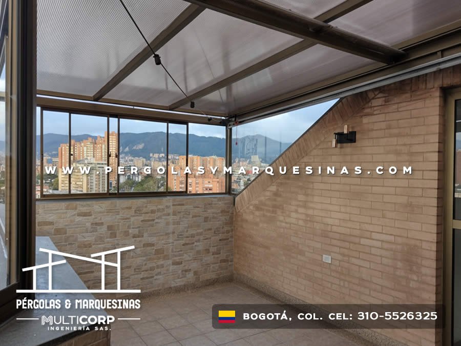 Cubierta de policarbonato con estructura metalica cafe sobre balcon con ventana panoramica y vista a montanas bogotanas en Bogotá, Colombia. Multicorp Ingeniería SAS.