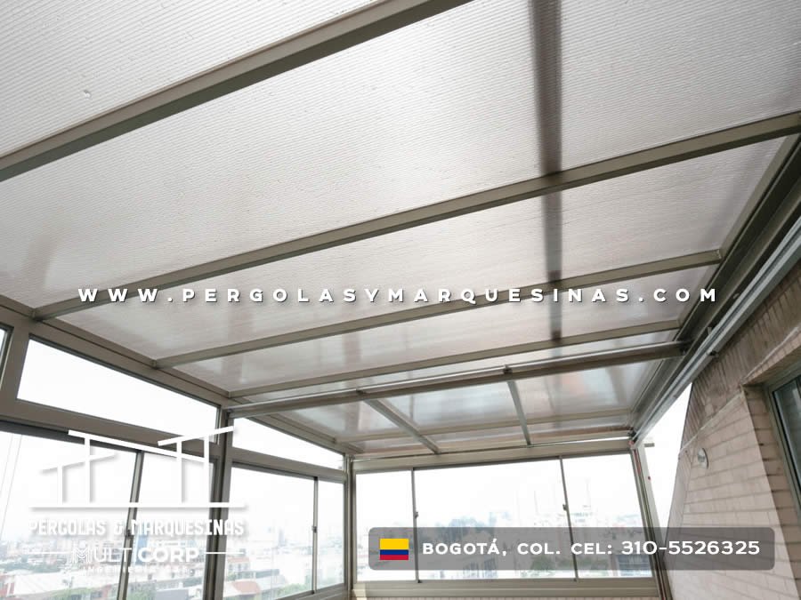 Cubierta de policarbonato con estructura de aluminio en balcon acristalado de apartamento con vista urbana en Bogotá, Colombia. Multicorp Ingeniería SAS.