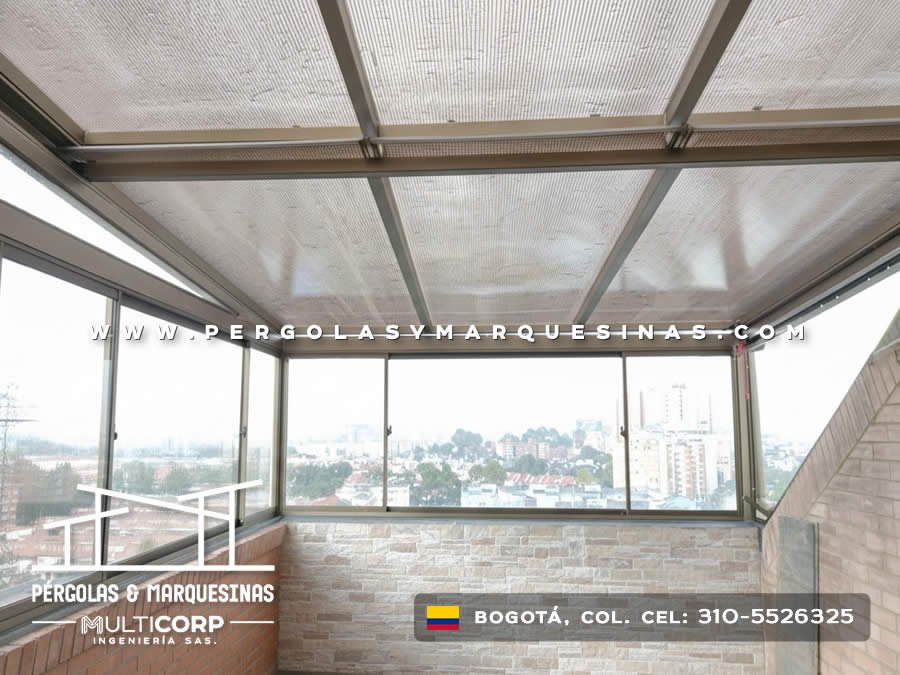 Techo de policarbonato con estructura metalica gris en balcon acristalado de apartamento con vista a la ciudad en Bogotá, Colombia. Multicorp Ingeniería SAS.