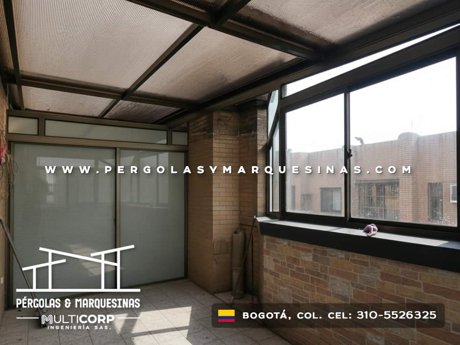 Pergola cerrada con techo de policarbonato y paneles de vidrio en terraza de casa con muro de ladrillo en Bogotá, Colombia. Multicorp Ingeniería SAS.
