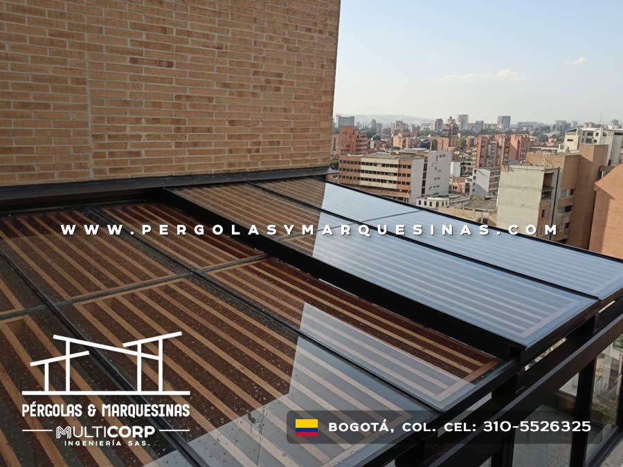 Pergola de madera con techo de policarbonato y estructura metalica negra en terraza de atico con vista urbana en Bogotá, Colombia. Multicorp Ingeniería SAS.