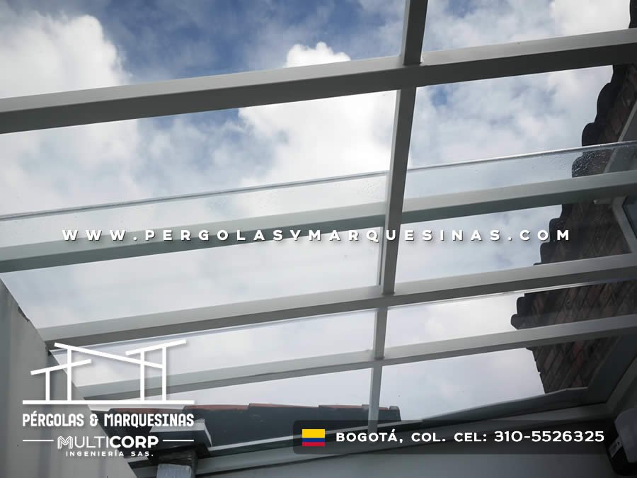 Techo de vidrio templado con estructura metalica gris en terraza de casa con muro de ladrillo en Bogotá, Colombia. Multicorp Ingeniería SAS.