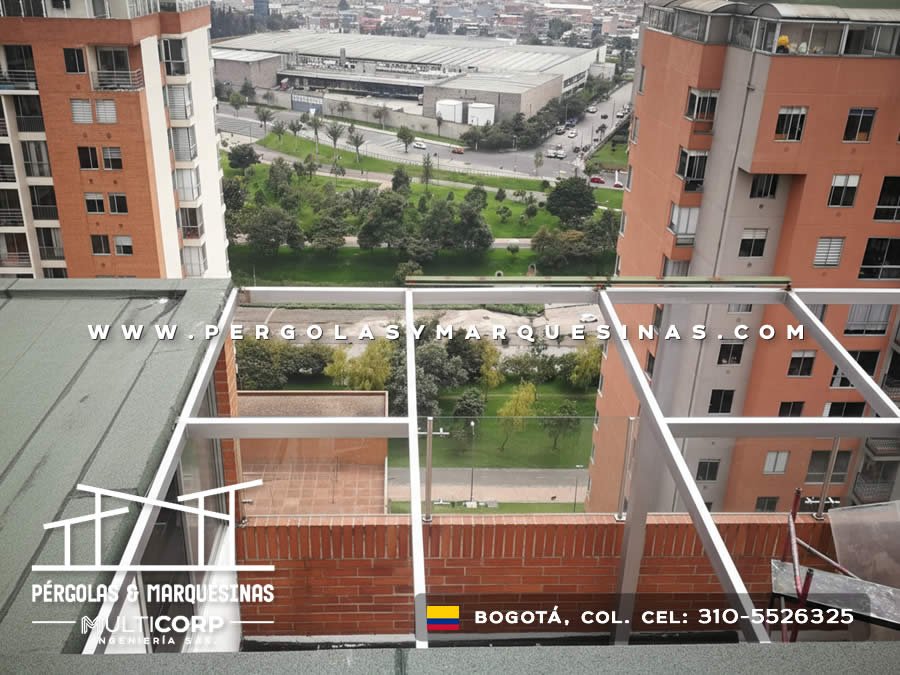 Pergola con estructura metalica gris en terraza de edificio con vista a parque urbano y edificaciones en Bogotá, Colombia. Multicorp Ingeniería SAS.