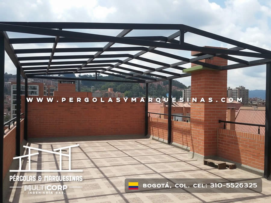 Pergola con estructura metalica negra en azotea de edificio con muro de ladrillo y vista a colinas en Bogotá, Colombia. Multicorp Ingeniería SAS.