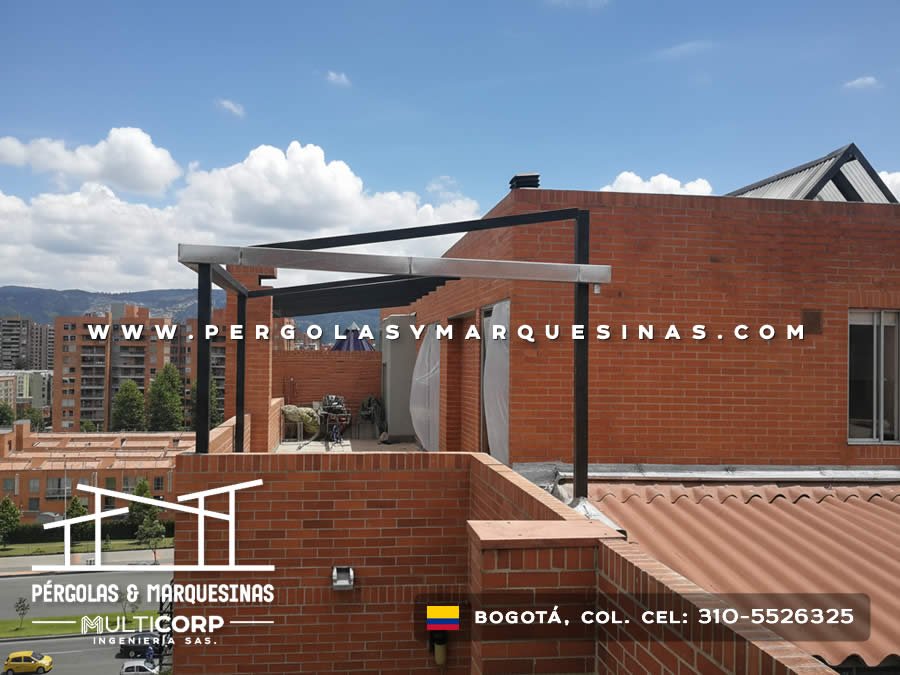 Marquesina con estructura metalica negra en azotea de edificio con muro de ladrillo y vista a edificaciones en Bogotá, Colombia. Multicorp Ingeniería SAS.