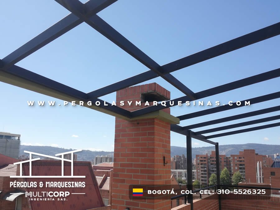 Estructura metalica negra para cubierta abierta en azotea con chimenea de ladrillo y vista a colinas urbanas en Bogotá, Colombia. Multicorp Ingeniería SAS.