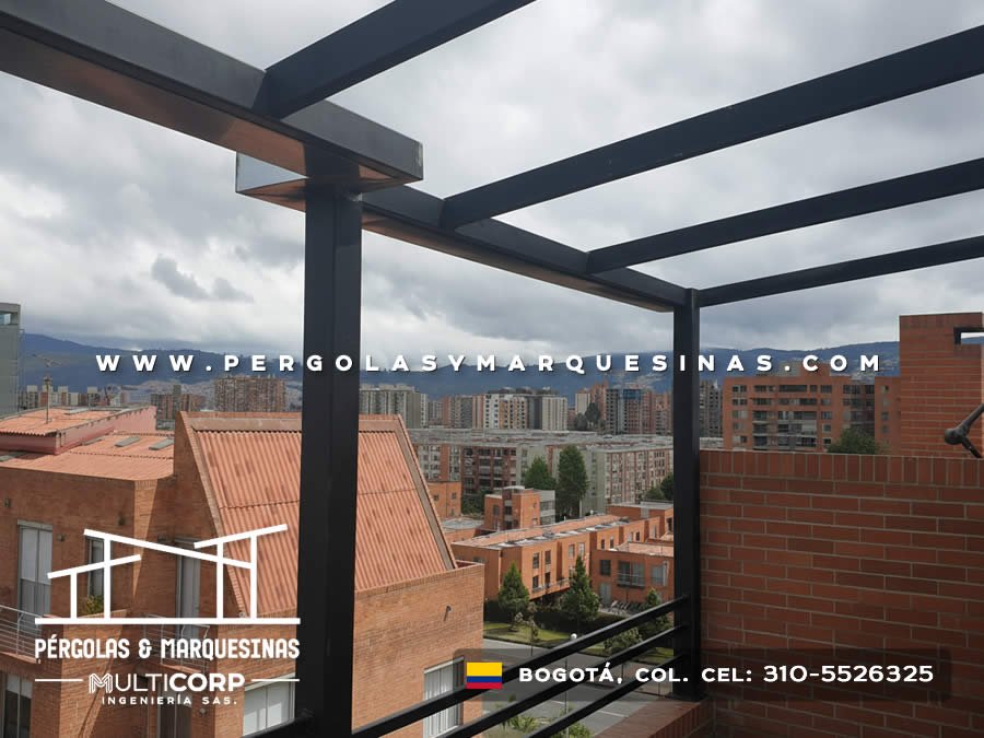 Pergola con estructura metalica negra en terraza de edificio con vista panoramica a edificaciones y montanas en Bogotá, Colombia. Multicorp Ingeniería SAS.